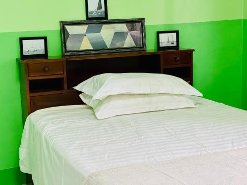 a green bedroom with a white bed and a green wall at Grace house in Suva