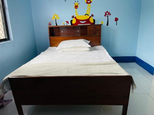 a bed with a wooden headboard in a room at Grace house in Suva