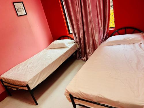 two twin beds in a room with red walls at Grace house in Suva