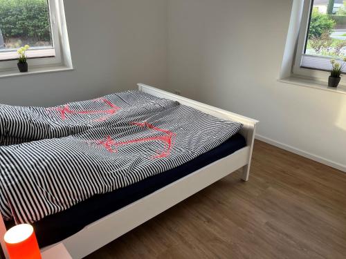 a bed in a room with red arrows on it at Haacksen - modernes Ferienhaus mit 4 Schlafzimmern, Garten und Grill in Klappholz
