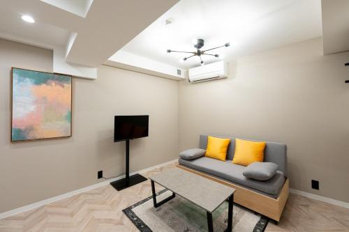 東京にあるbelle ville Kagurazakaのソファとテレビのあるリビングルーム