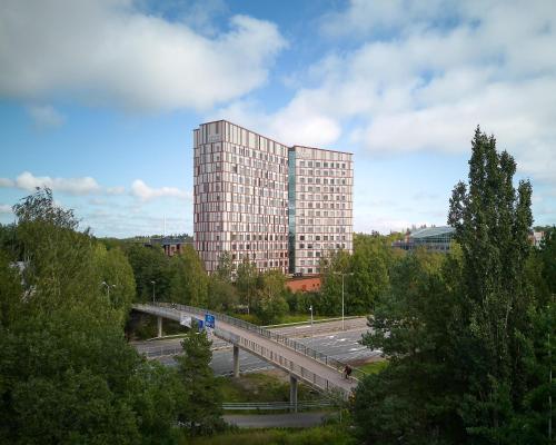 a tall building with a bridge in front of it at Noli Otaniemi in Espoo