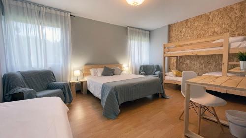 een slaapkamer met een bed en 2 stoelen en een bureau bij Hotel A Estrada Rooms in A Estrada