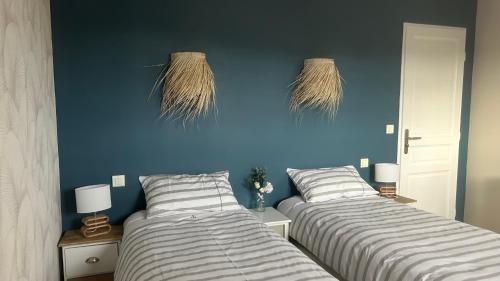 ロクブリューヌ・シュル・アルジャンにあるGîte des Figuiersの青い壁のベッドルーム1室(ベッド2台付)