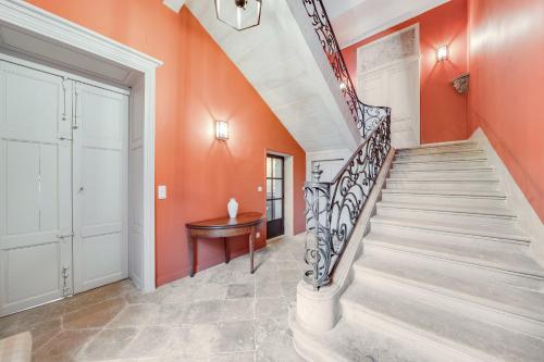 uma escada numa casa com uma parede laranja em Écrin exclusif au sein d'un château en Bourgogne em Bretenière