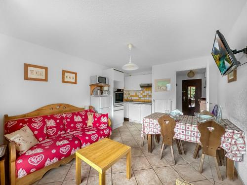 un salon avec un canapé rouge et une table dans l'établissement CR103 - 2 Pièces Coin Montagne 6 Pers proche base, aux Carroz d'Arâches
