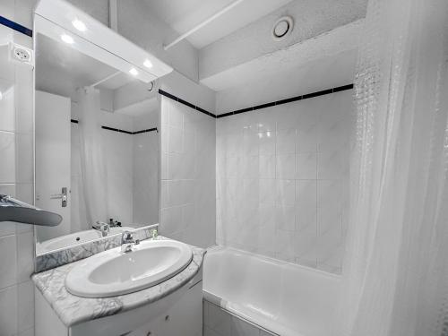 La salle de bains blanche est pourvue d'un lavabo et d'une baignoire. dans l'établissement CR103 - 2 Pièces Coin Montagne 6 Pers proche base, aux Carroz d'Arâches