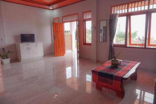Tobay Family Home في توك توك: غرفة معيشة مع طاولة وغرفة مع نوافذ