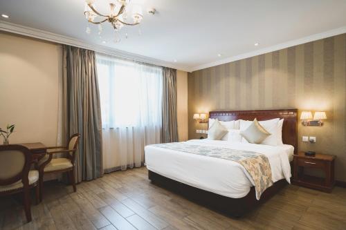 a hotel room with a bed and a desk and a chandelier at Sarova Woodlands Hotel and Spa in Nakuru