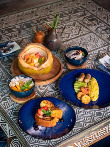 een tafel met blauwe borden met voedsel erop bij Blue Karma Village in Seminyak