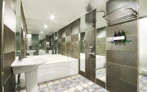La salle de bains est pourvue d'une baignoire, d'un lavabo et d'une douche. dans l'établissement Rosso Hotel, à Busan