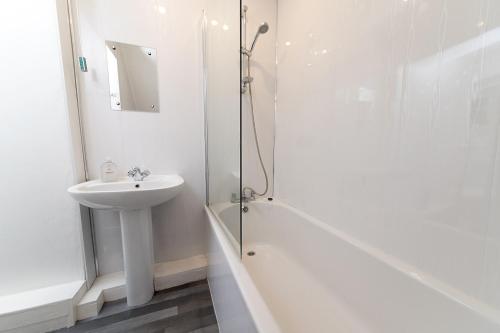 uma casa de banho branca com um lavatório e um chuveiro em Suggitt House em Hartlepool