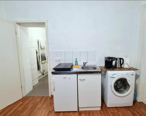 uma cozinha com uma máquina de lavar roupa e um lavatório em Studio Apartement in Halle em Halle an der Saale