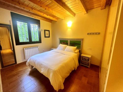 a bedroom with a large white bed in a room at Chalet en la naturaleza cerca de Segovia y Ávila in Ituero y Lama