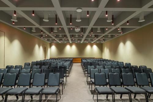an empty lecture hall with blue chairs and lights at The Valle by Kondody Hotels in Munnar