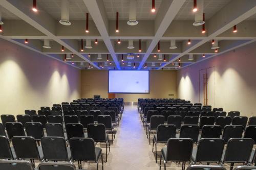 a lecture hall with chairs and a projection screen at The Valle by Kondody Hotels in Munnar
