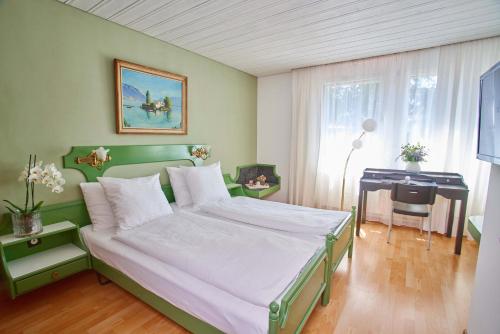 a bedroom with a bed and a desk in it at Hotel La Balance self check-in in Biel