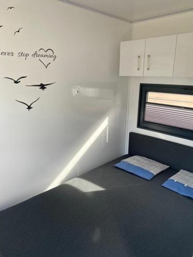 a room with a bed with birds on the wall at Hausboot - Meeresbrise in Heiligenhafen