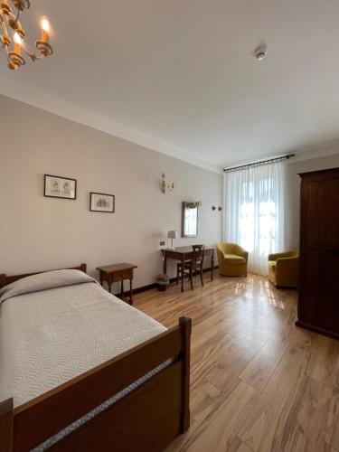 a bedroom with a bed and a dining room at Hotel La Torre in Castiglione dʼIntelvi