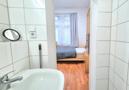 uma casa de banho com um lavatório e uma cama num quarto em Studio Apartement in Halle em Halle an der Saale