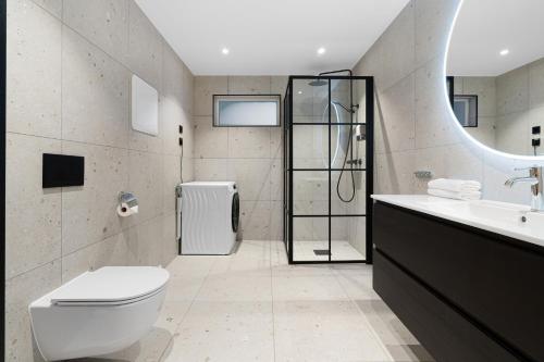 a bathroom with a toilet and a sink and a shower at Enter Tromsø - The Mountain View in Tromsø