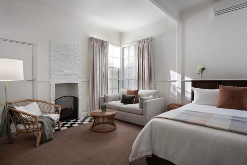 a bedroom with a bed and a chair and a fireplace at Stanbridge House- perfect escape, modern comforts in Daylesford