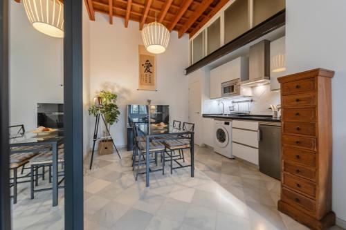 a kitchen and dining room with a table and chairs at Arco del Postigo in Seville