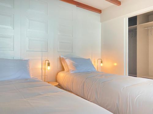 twee bedden naast elkaar in een slaapkamer bij Myrtus - House with sea view and garden in Funchal