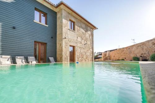a swimming pool in front of a house at RB Ganfei House in Valença