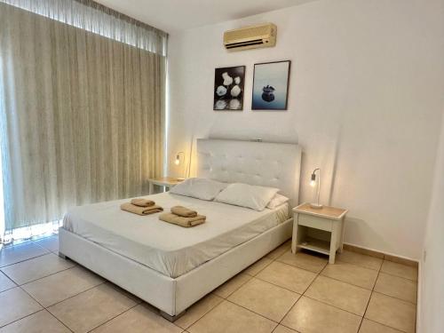 a bedroom with a bed with two towels on it at King's Holiday Apartments in Paphos City