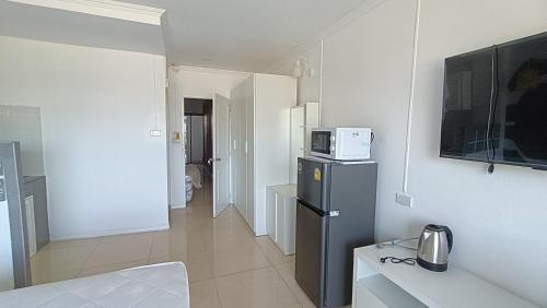 a small kitchen with a refrigerator and a microwave at Boho Rent A room in Jomtien Beach