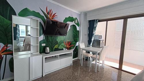 a room with a desk and a table with a television at Boho Rent A room in Jomtien Beach
