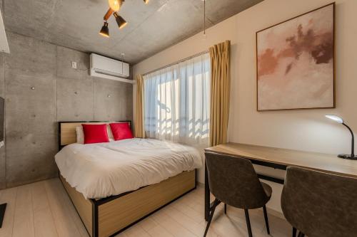niewielka sypialnia z łóżkiem i biurkiem w obiekcie Ferio Kamata w Tokio