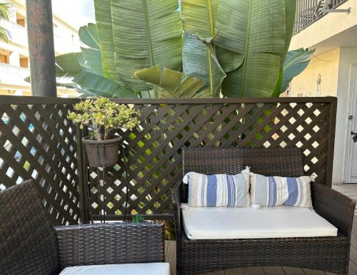 two wicker chairs with pillows on a patio at King's Holiday Apartments in Paphos City