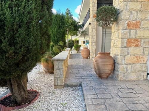 a row of large vases sitting next to a building at King's Holiday Apartments in Paphos City