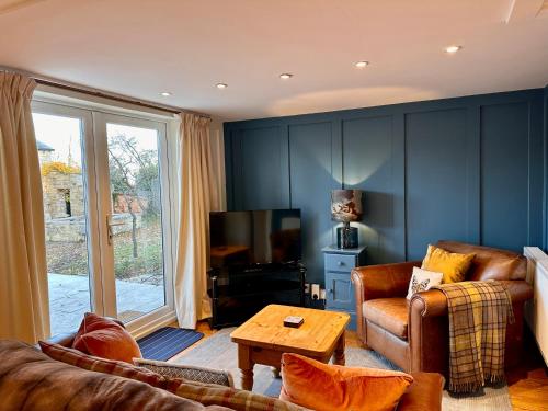 uma sala de estar com um sofá e uma televisão em Octon Cottages Luxury 1 and 2 Bedroom cottages 1 mile from Taunton centre em Taunton