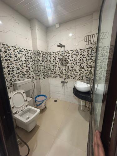 a bathroom with a toilet and a sink at Hotel Ankit Near Assi Ghat in Varanasi