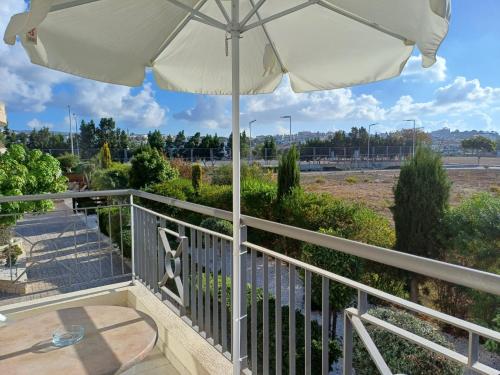 a balcony with an umbrella and a table at King's Holiday Apartments in Paphos City