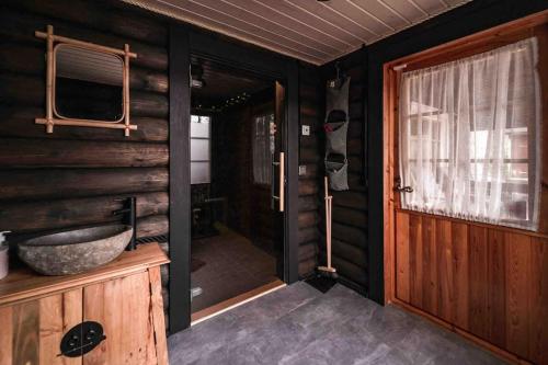 a bathroom with a sink and a wooden wall at Ihana paikka jossa ulkoporeallas sekä pihasauna in Loppi