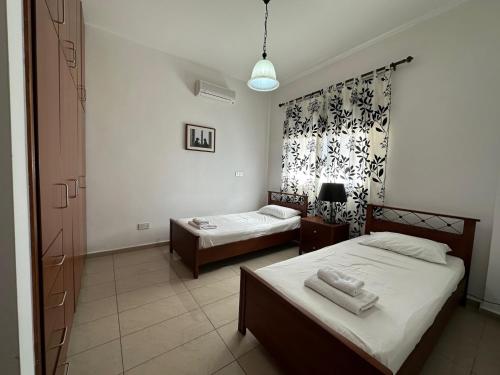 a bedroom with two beds and a window at King's Holiday Apartments in Paphos City