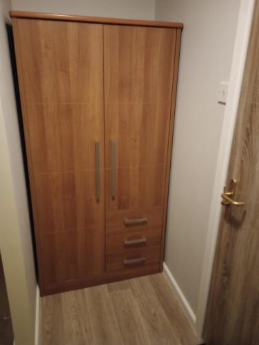 a large wooden cabinet in a corner of a room at QT in Gildingwells