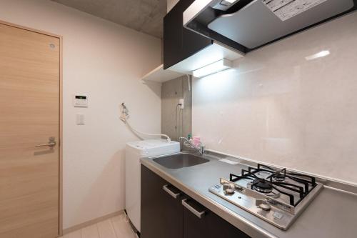 a small kitchen with a sink and a stove at Ferio Kamata in Tokyo