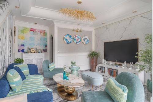 a living room with blue chairs and a tv at Súp Lơ House (Broccoli's House) in Da Lat