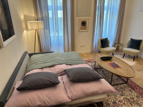 um quarto com uma cama com almofadas e uma mesa em Boutique Apartment em Viena