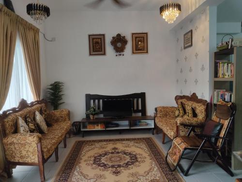 a living room with two couches and a tv at Hulu Yam Musliim Homestay in Batang Kali
