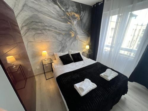 sypialnia z dużym łóżkiem z dwoma ręcznikami w obiekcie Le Cannois, Appartement de star 3 chambres w Miluzie