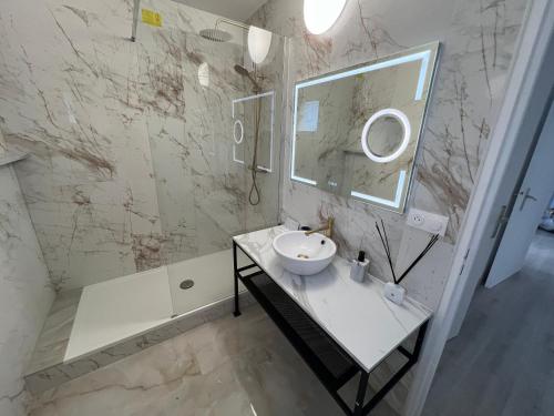 une salle de bain blanche avec un lavabo et un miroir dans l'établissement Le Cannois, Appartement de star 3 chambres, à Mulhouse
