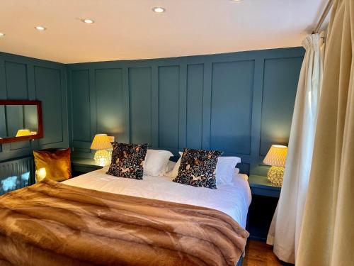 a bedroom with blue walls and a bed with pillows at Octon Cottages Luxury 1 and 2 Bedroom cottages 1 mile from Taunton centre in Taunton