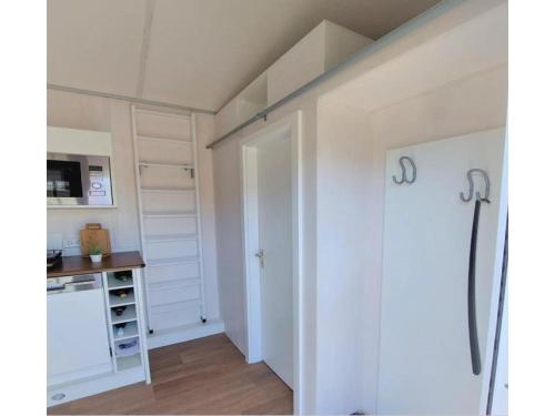 een kamer met een witte deur en een keuken bij Tiny House Paradies in Wustermark