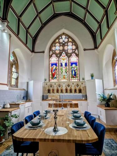 a large room with a table and a stained glass window at Peaceful Church Getaway in Middleton One Row